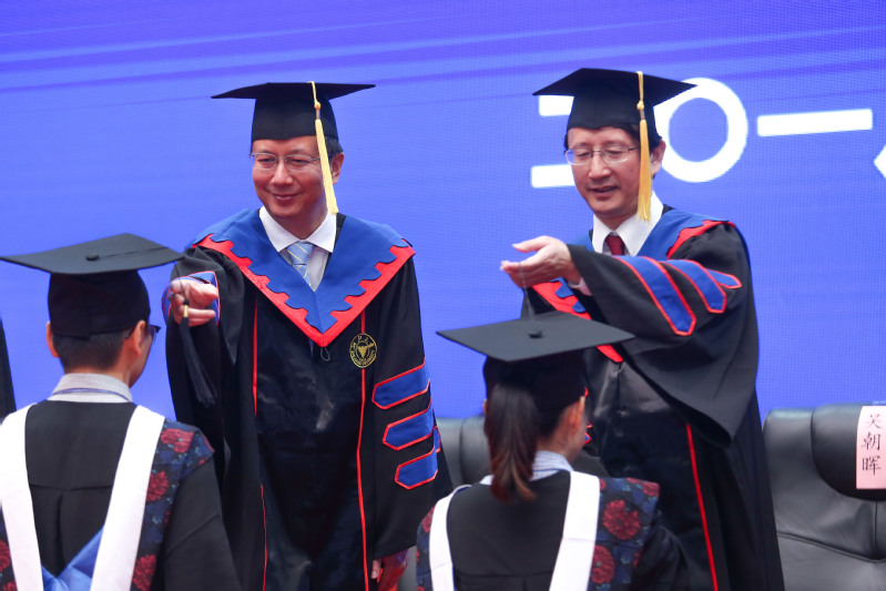 Prof. ZOU, secretary of the Party committee, and President WU moved the graduates' tassels.