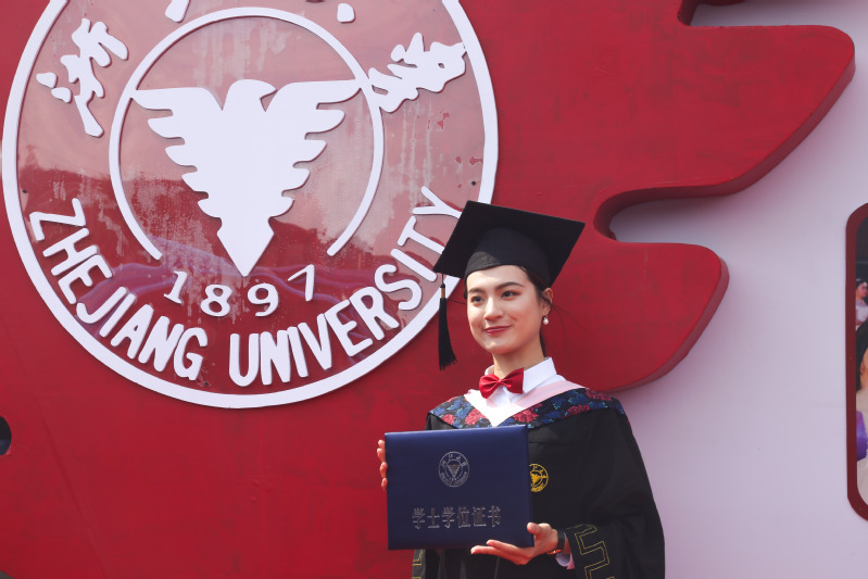A graduate posed with her diploma.